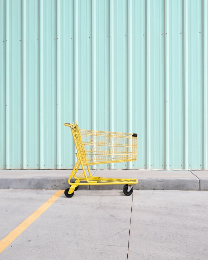 Yellow Shopping Cart On Footpath Against Wall