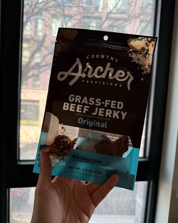 Someone holding package of Country Archer beef jerky.