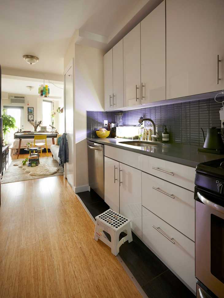 Aquarium and small appliances on dark countertop in kitchen with white cabinetry.
