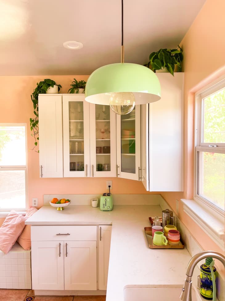 A peachy kitchen with white cabinets and light countertops