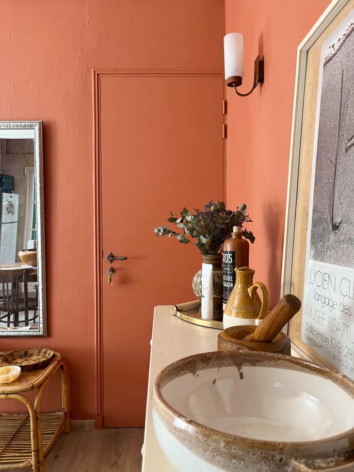 Un apartamento con color terracota en la pared y muebles reciclados