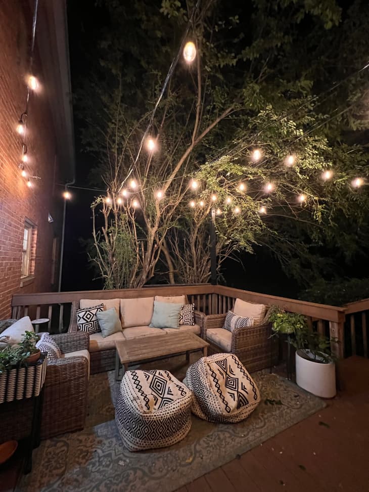 Floor pillows and string lights in outdoor patio area.