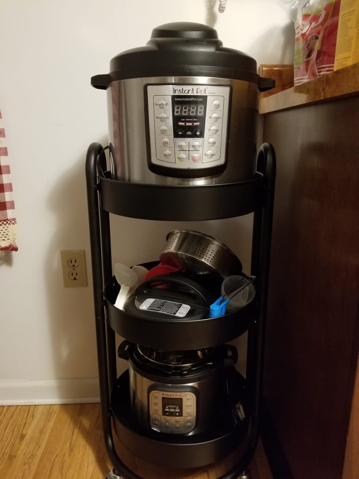 Instant Pot on a three-tier black metal stand with kitchen accessories and a second Instant Pot below.