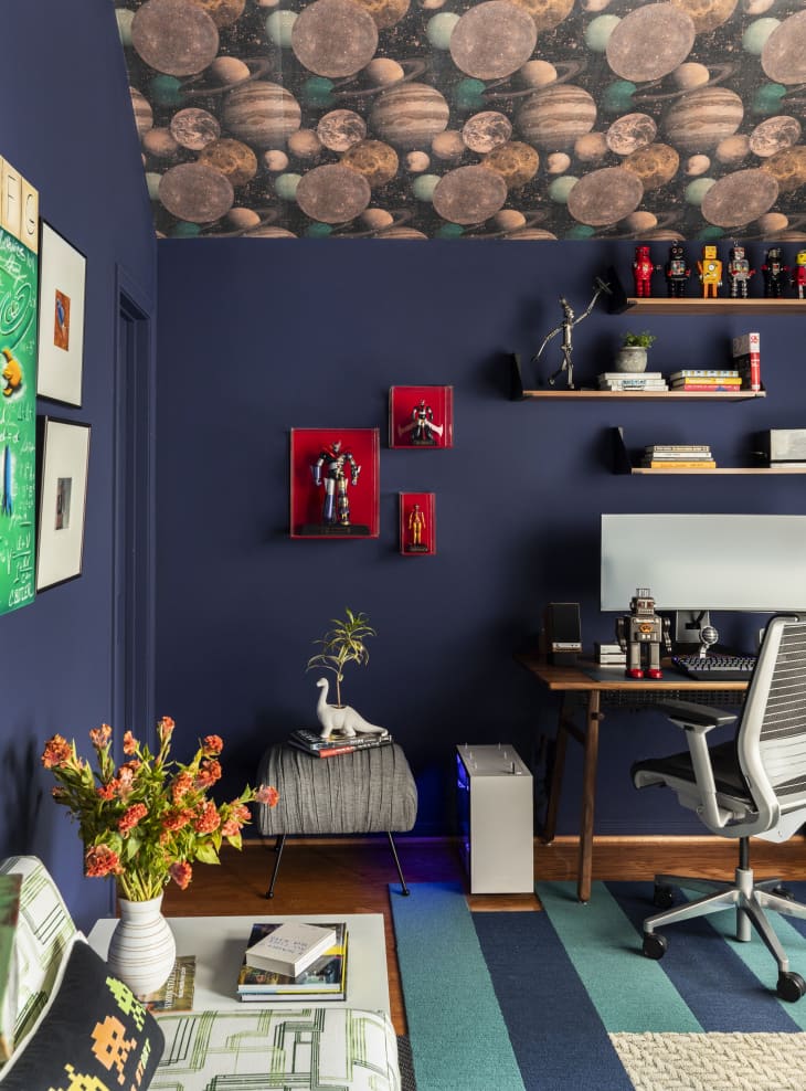 Workspace with navy walls and planet wallpaper on ceiling