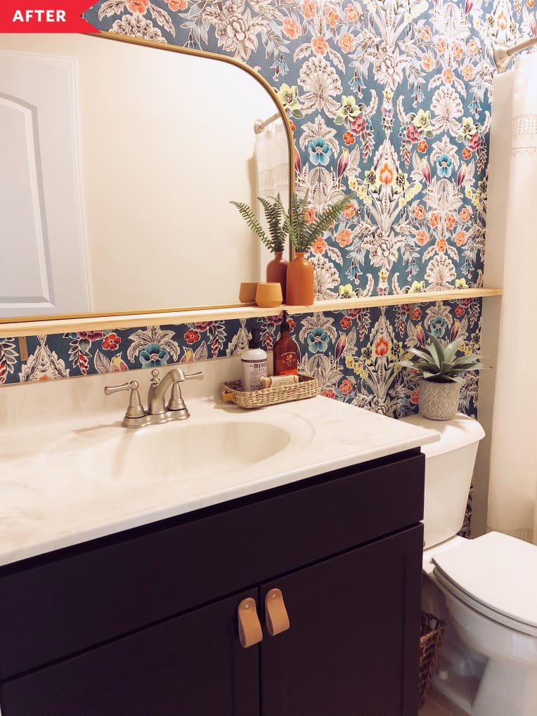 After: bathroom with black vanity, colorful patterned wallpaper, and a shelf for the mirror