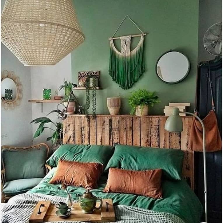 rustic pallet bed with headboard against a green wall