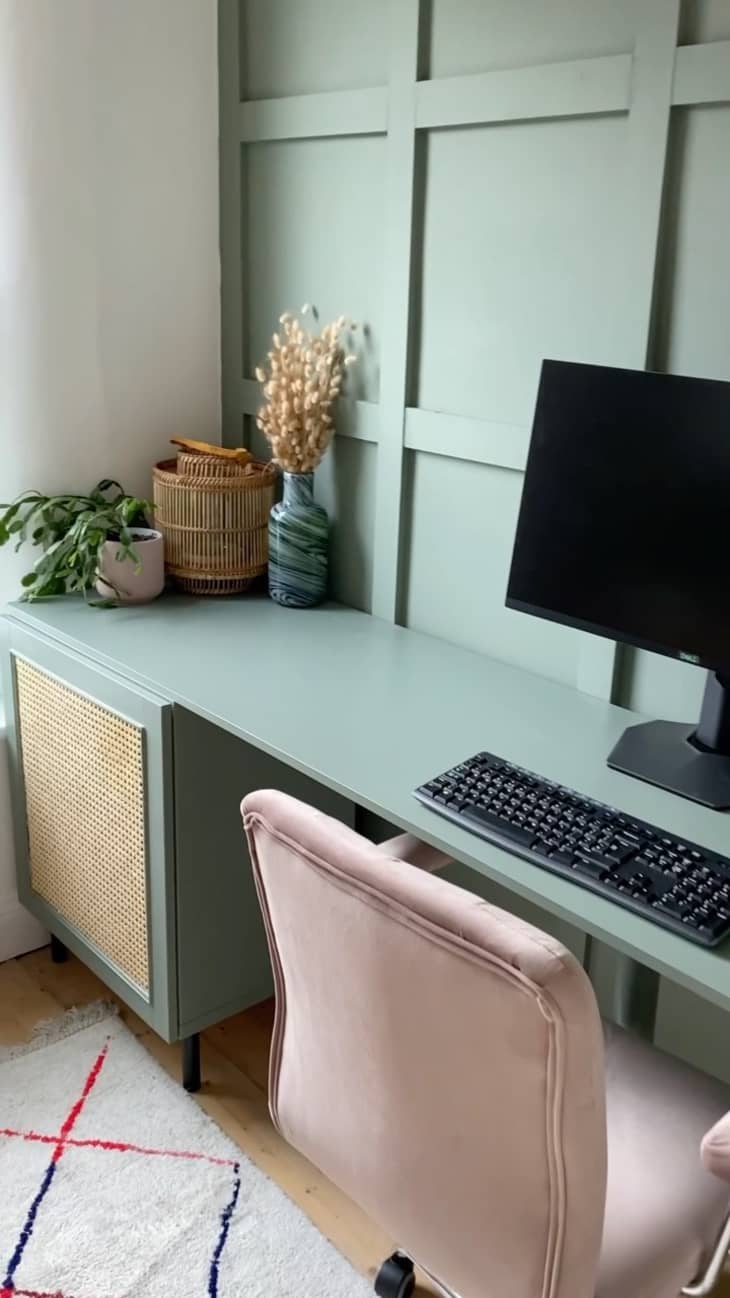 a home office features a sage green wall and desk in same paint color
