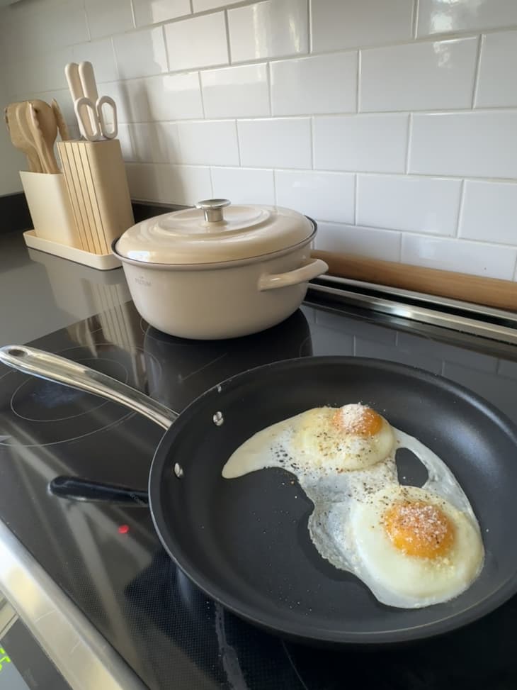 two eggs cooking in an All-Clad fry pan