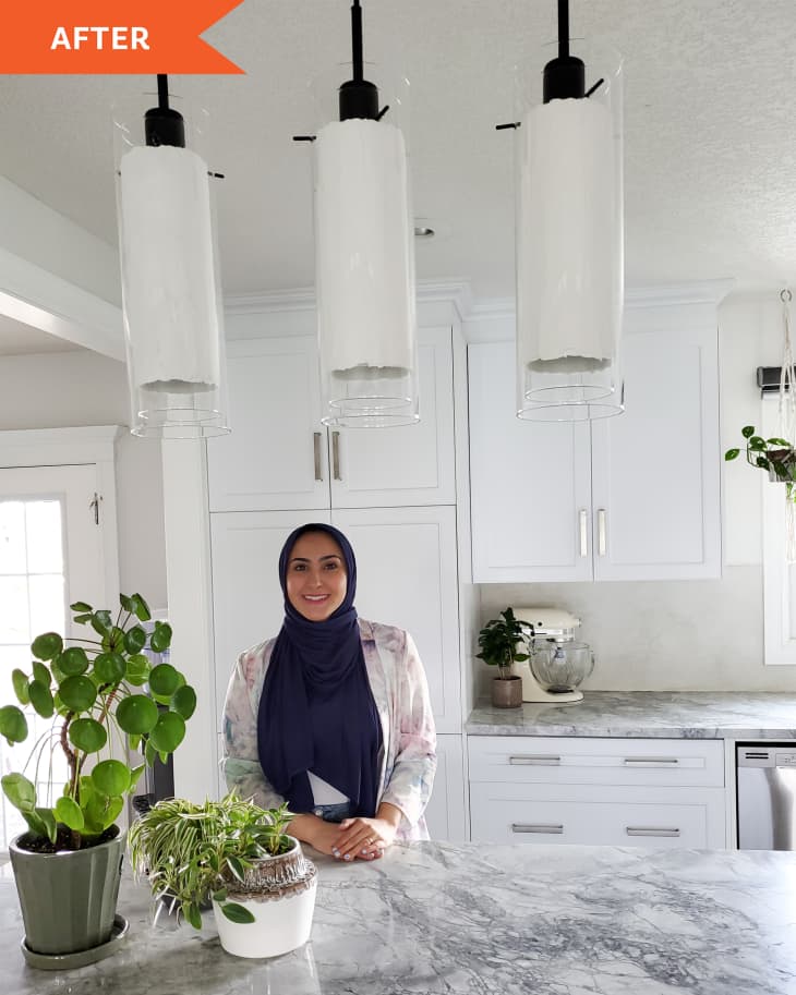 After photo DIYer with her 3 DIYed glass pendant lights in a white kitchen