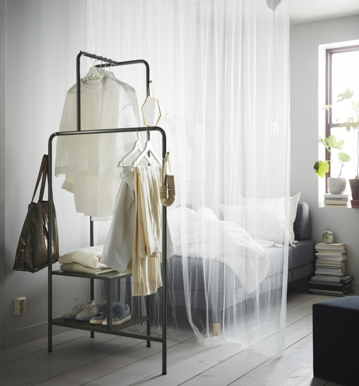 IKEA metal clothing rack and daybed behind curtain