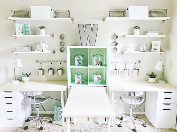 Divided all white workspace with three desks