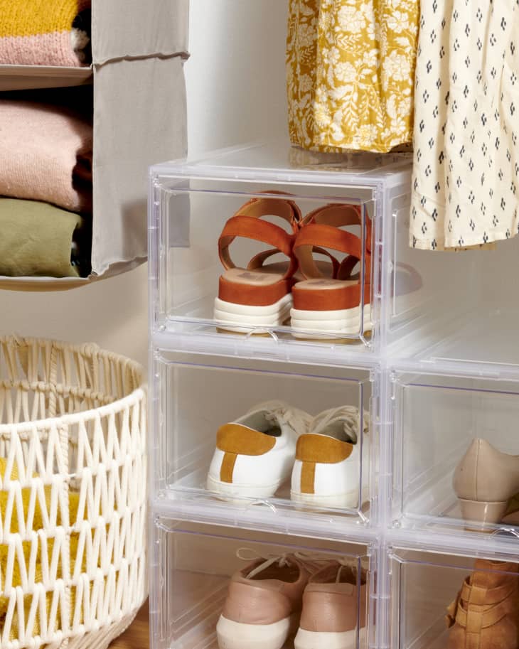 closet scene with shoes in clear plastic organizer boxes with a basket, hanging organizer, and hanging clothes visible