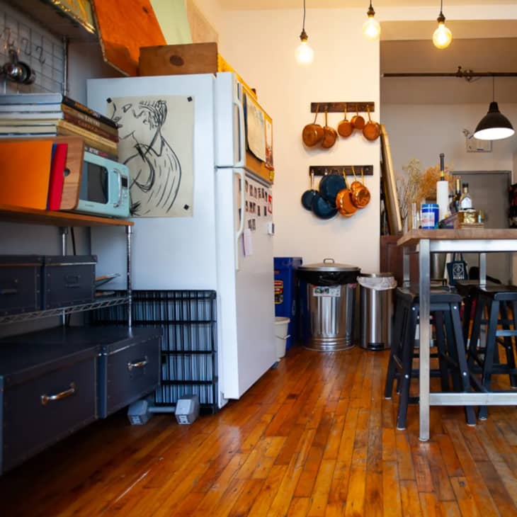 a Brooklyn loft industrial kitchen with exposed lightbulbs and copper pots