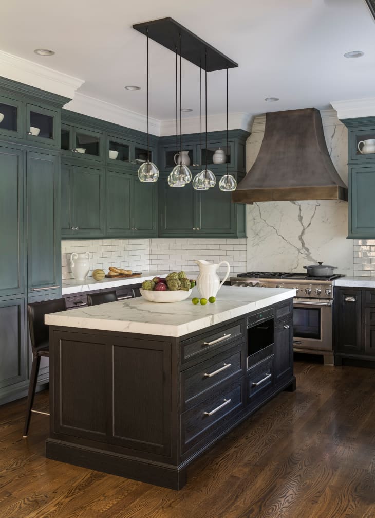 The kitchen features a large dark wood island with a marble top.