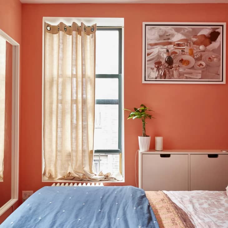 a small bedroom with bright coral painted walls