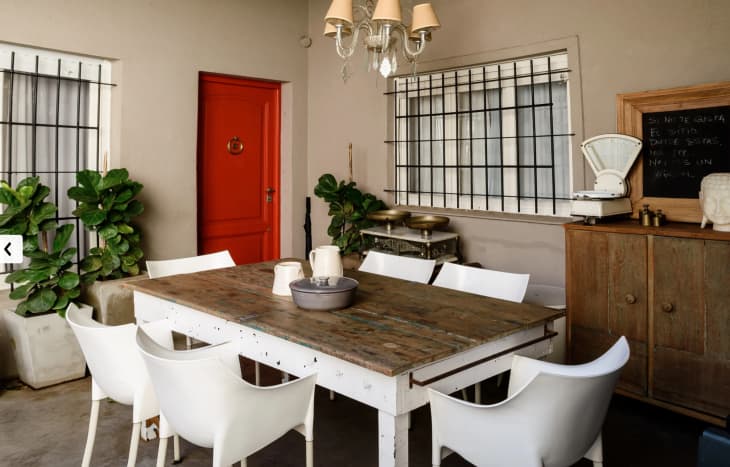 a beige dining room with a bright red door
