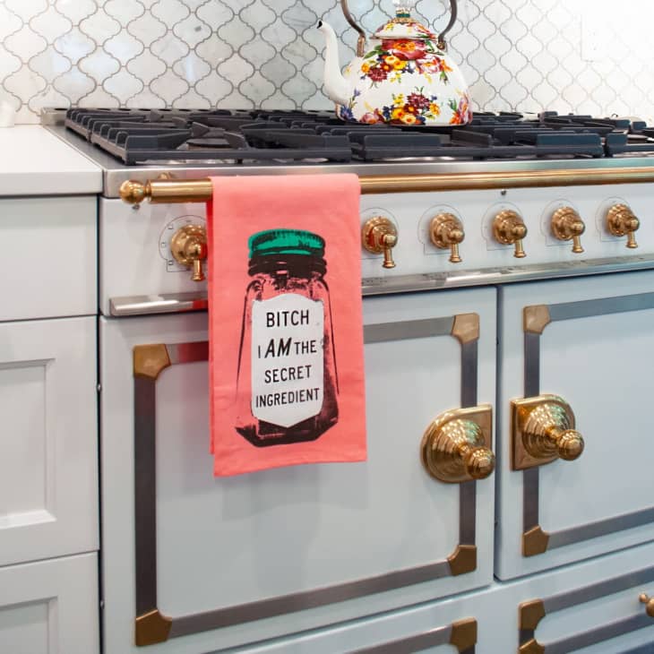 gray cabinets with copper hardware, a kitchen towel, and floral teapot