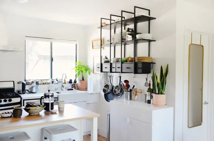 a white kitchen with black open shelving