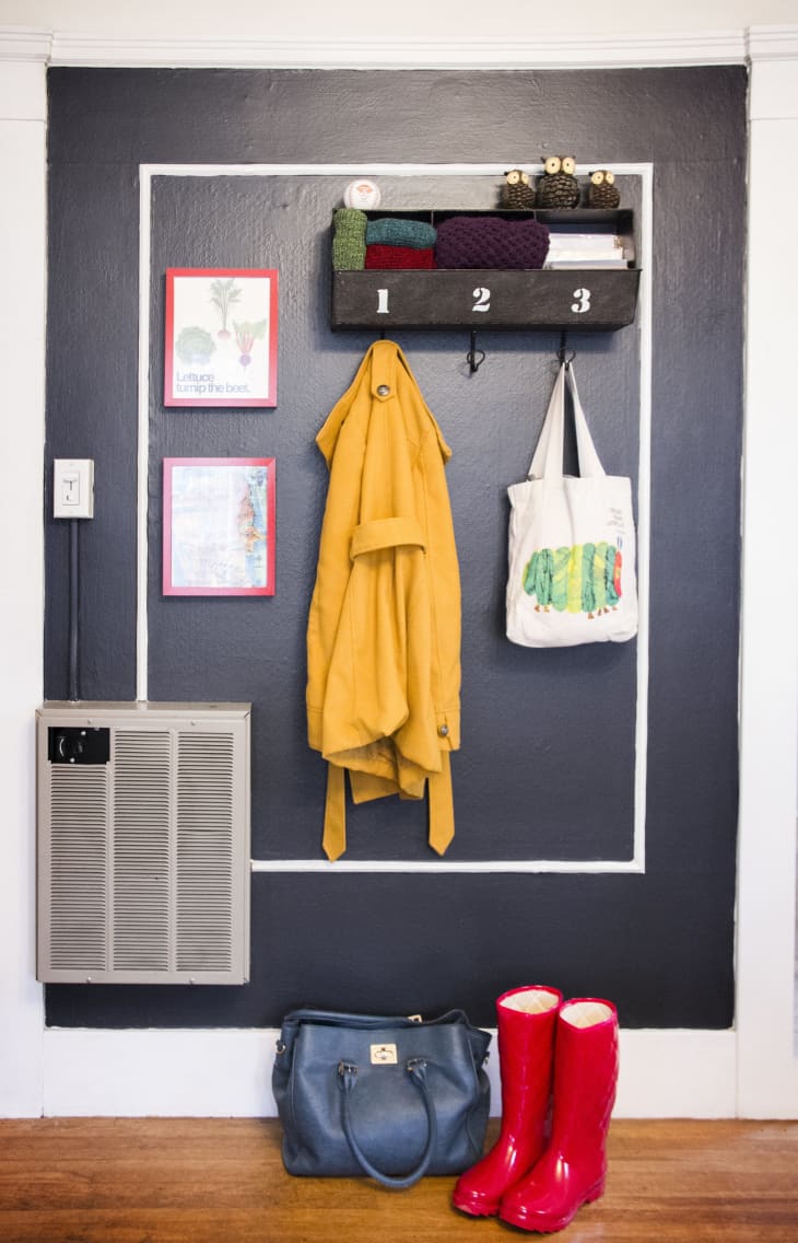 A framed "landing space" in a small apartment that has a space to hold coats, bags, and other essentials