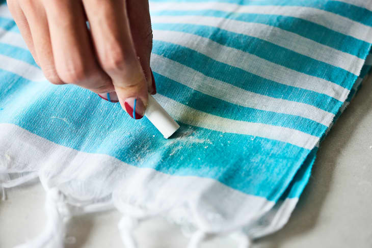 Using chalk to treat a grease stain on a kitchen towel