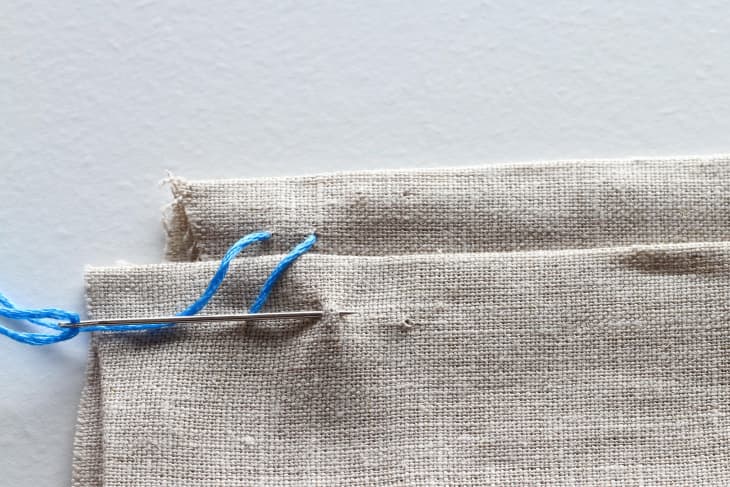 Two diagonal stitching with blue thread in canvas