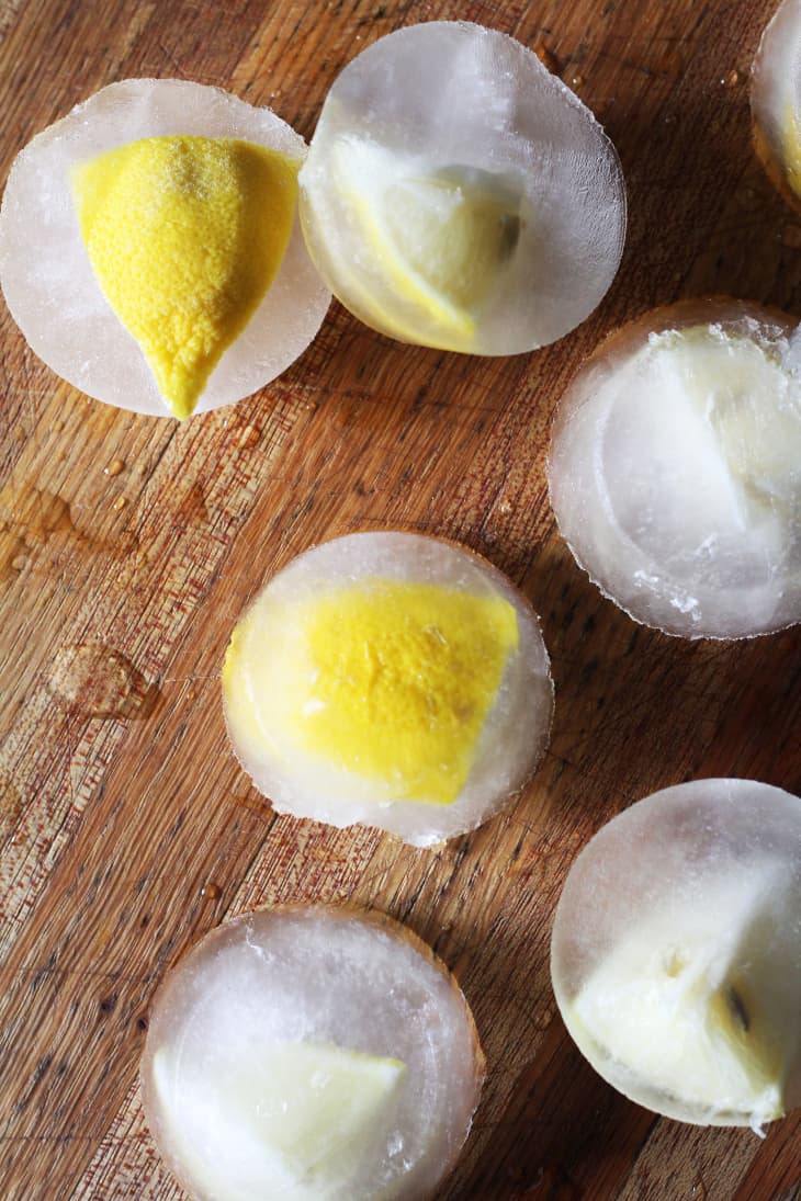 Circular ice molds with lemons frozen in them (a solution for a smelly garbage disposal) lay on a table
