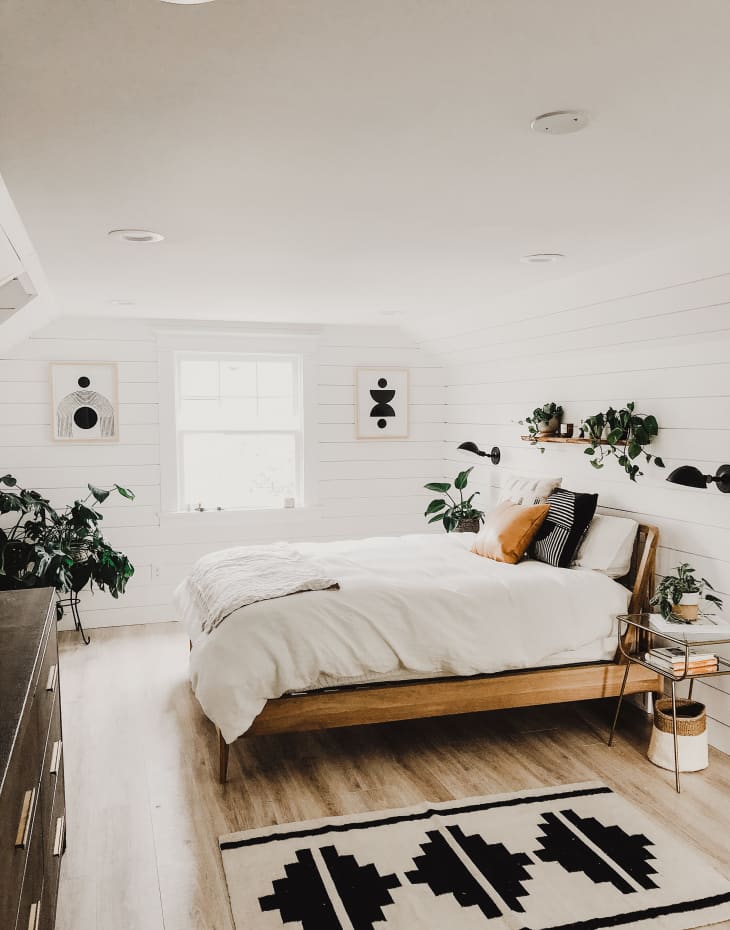 A bedroom with black and white artwork and bedding.