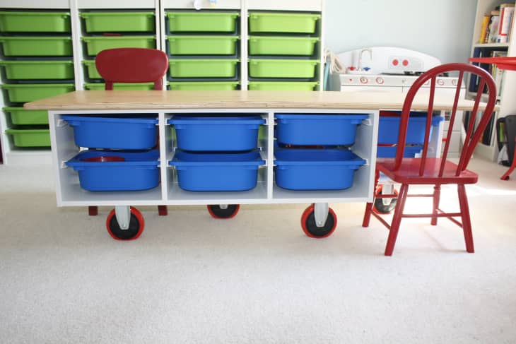 Trofast storage offers a play surface and desk by placing a table top on a low unit (on wheels, no less) and maximizing vertical storage with the six-drawer-high taller units