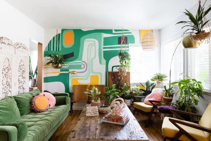 a living room with an abstract wall with a green and yellow pattern