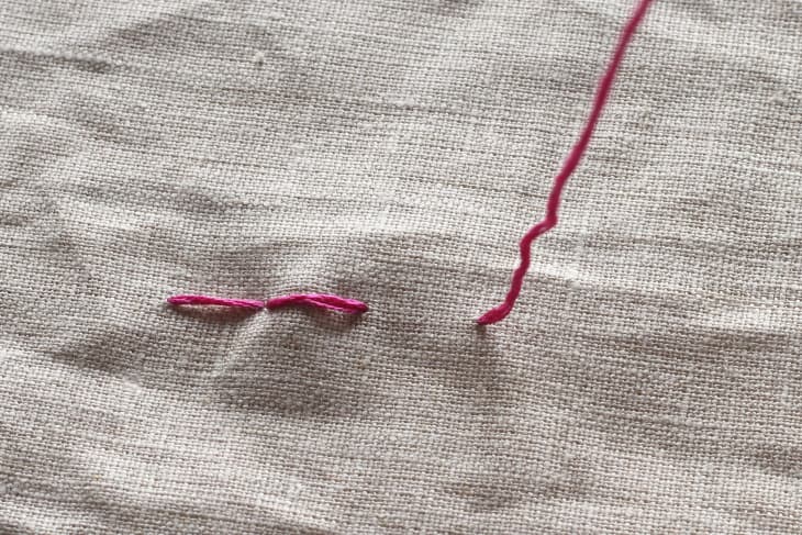 thread being pulled through canvas for third stitching.