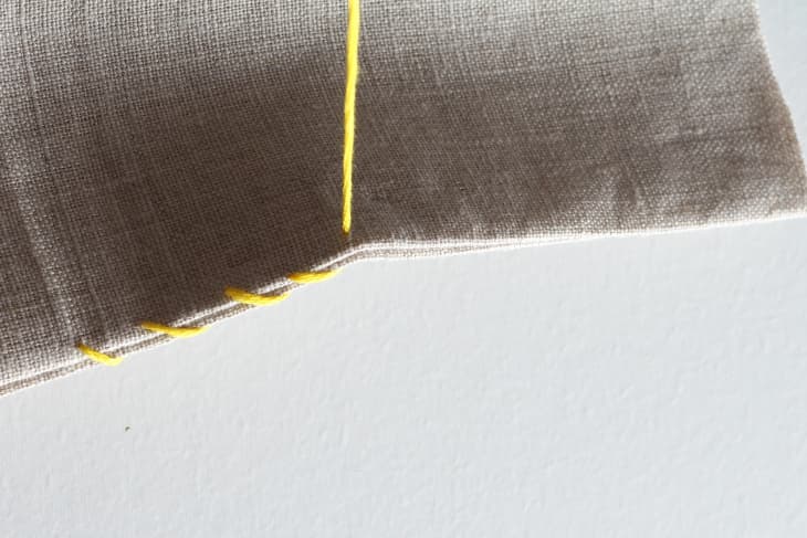 yellow thread pulled through canvas