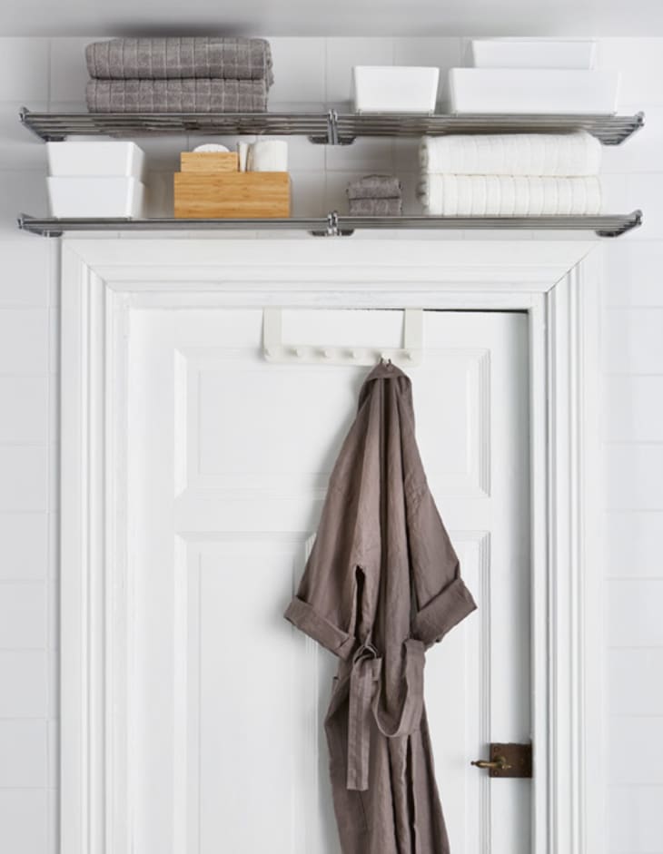 Shelves above the bathroom door with folded towels on them.