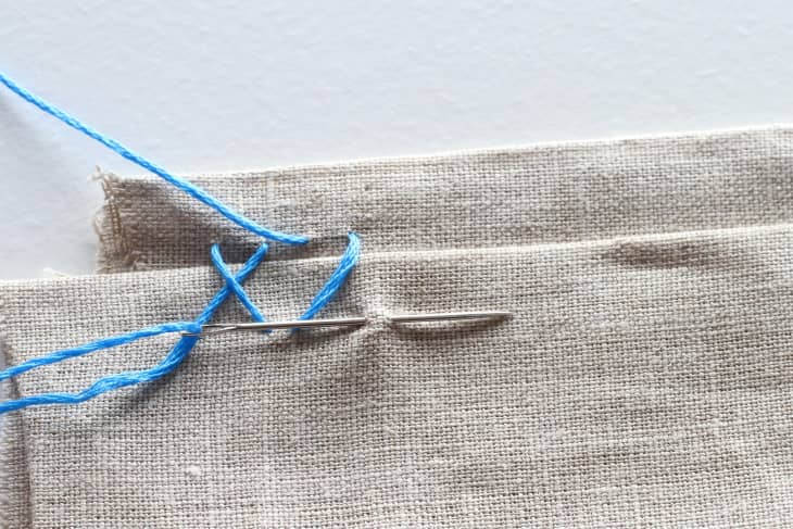 Needle goes over third stitch in canvas material.