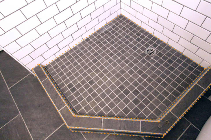 Orange dotted lines are seen along the shower pan, meaning caulk along the corners and every "change of plane"