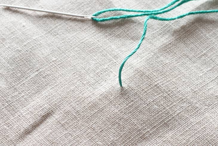 green thread knot tied in canvas material