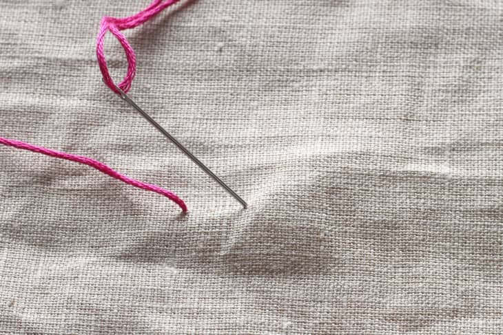 Pink threaded needle in canvas material
