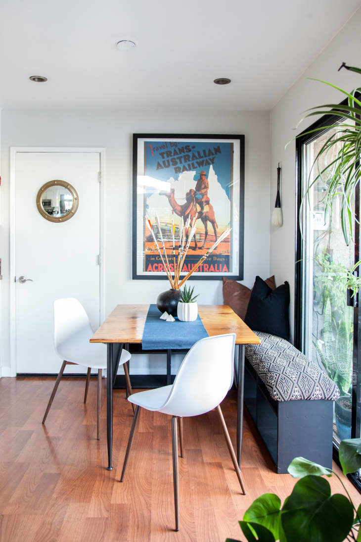 small living room with white chairs and camel painting