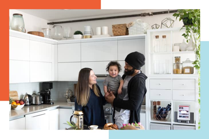 Family holding child in kitchen