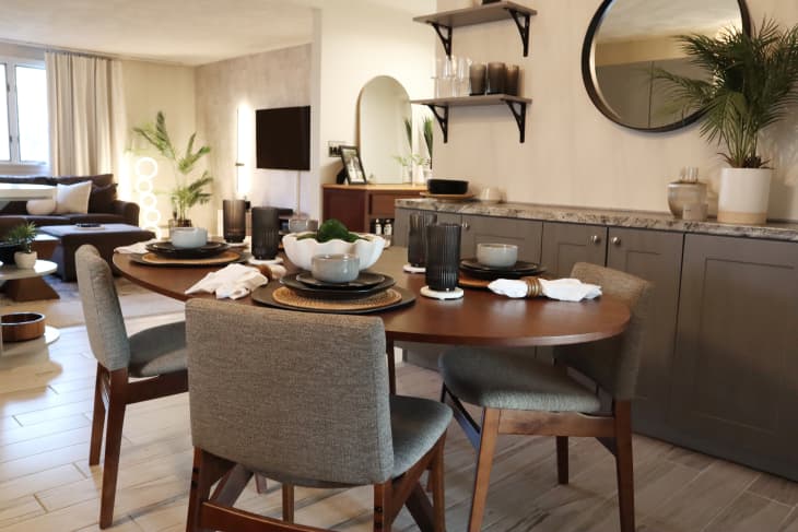Dining room with dark wood colored dining table, grey and wood dining chairs, and a taupe and marble credenza.