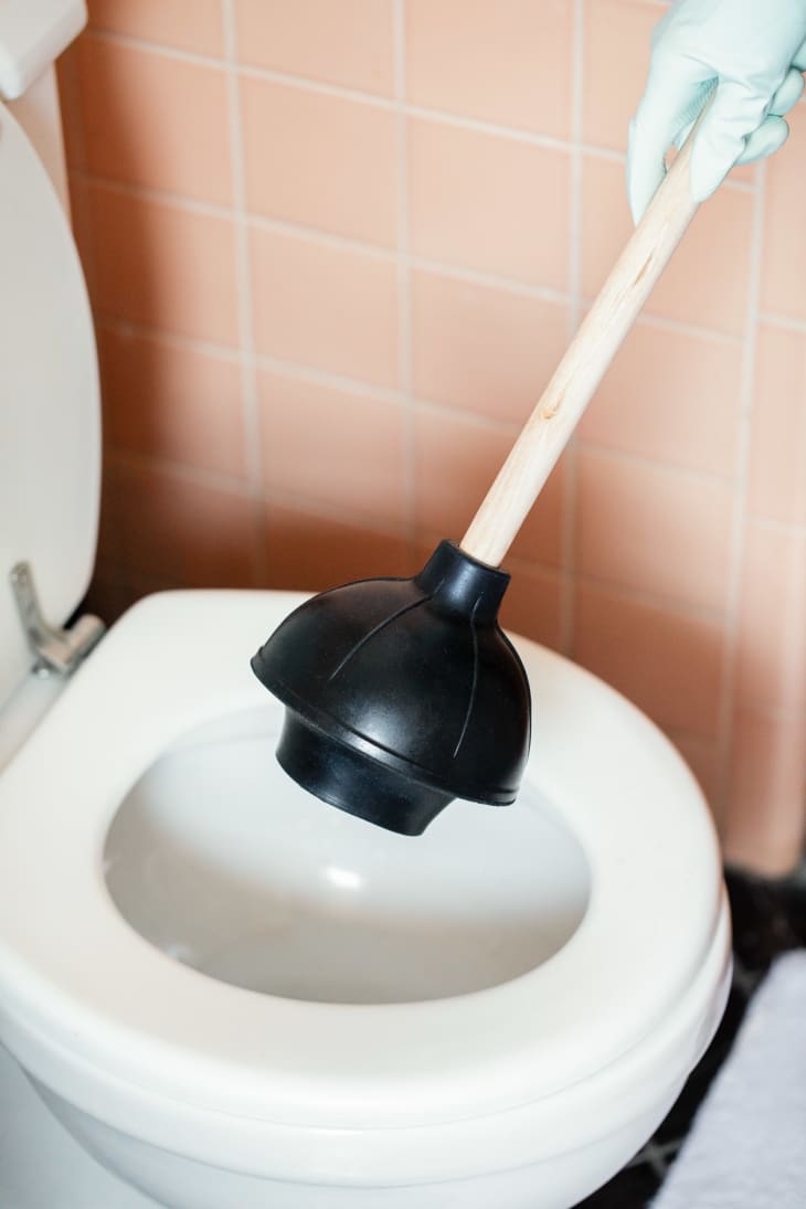 Using a toilet plunger in the bathroom