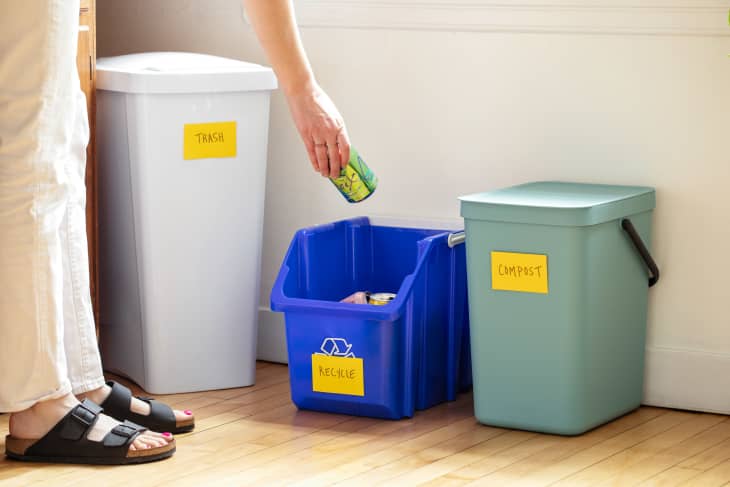 Throwing away can into recycling bin