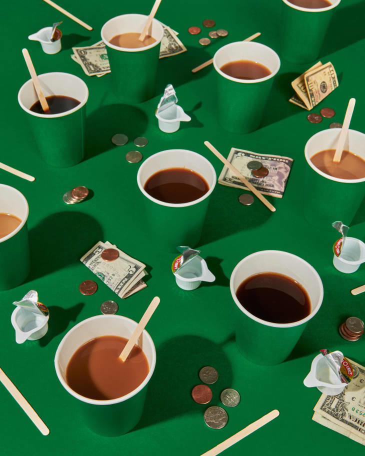 Coffee cups, cash, change, stir sticks on a green background