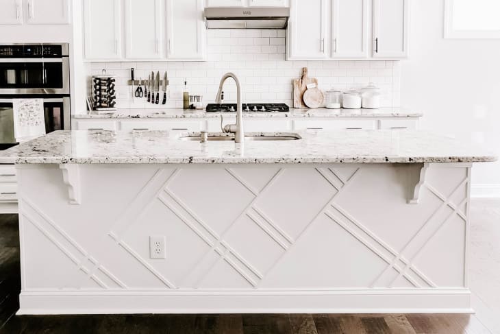 White kitchen island with relief pattern in white kitchen
