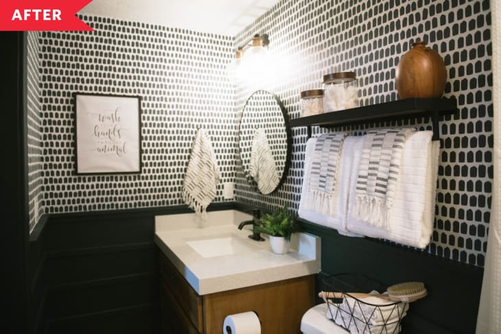 After: Bathroom with green wainscoting and green and white patterned wallpaper, wood vanity, and floating shelves