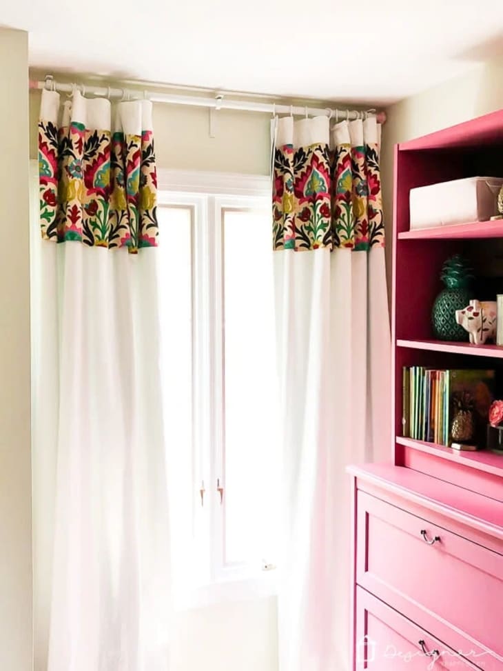 White curtains with colorful trim at the top edge