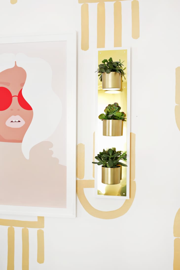 vertical brass wall planter with three plants