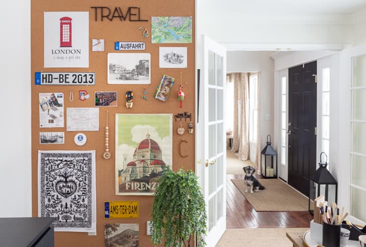 wall covered in corkboard and decorated with travel souvenirs