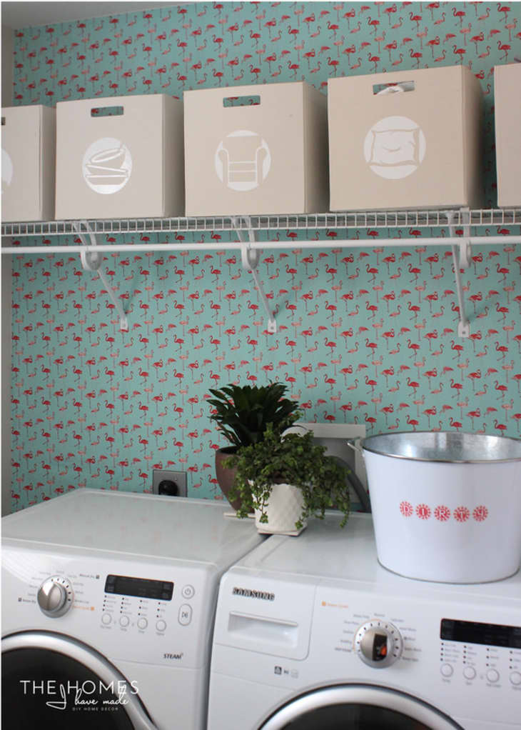 laundry room with teal flamingo patterned paper on the walls
