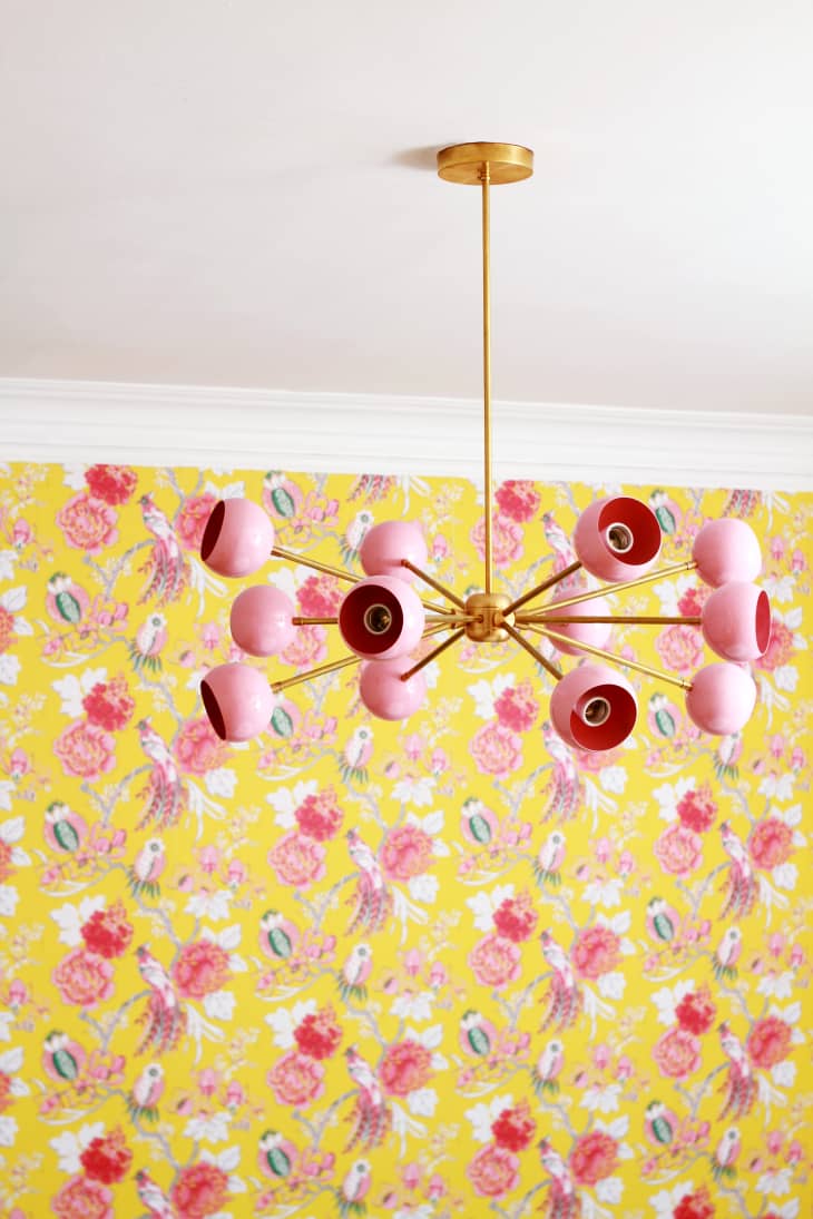Room with yellow floral wallpaper and pink multi-globed light fixture