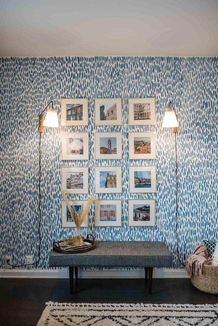 accent wall painted with blue brush strokes and a grid of artwork